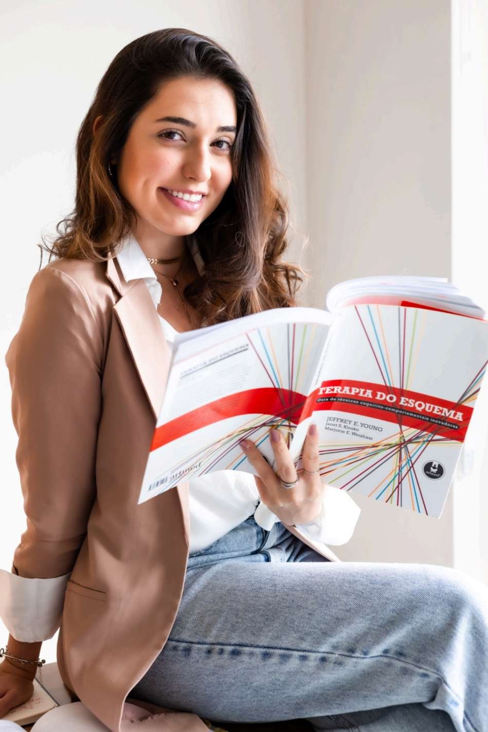 Bruna Lisboa com um livro sobre Terapia do Esquema